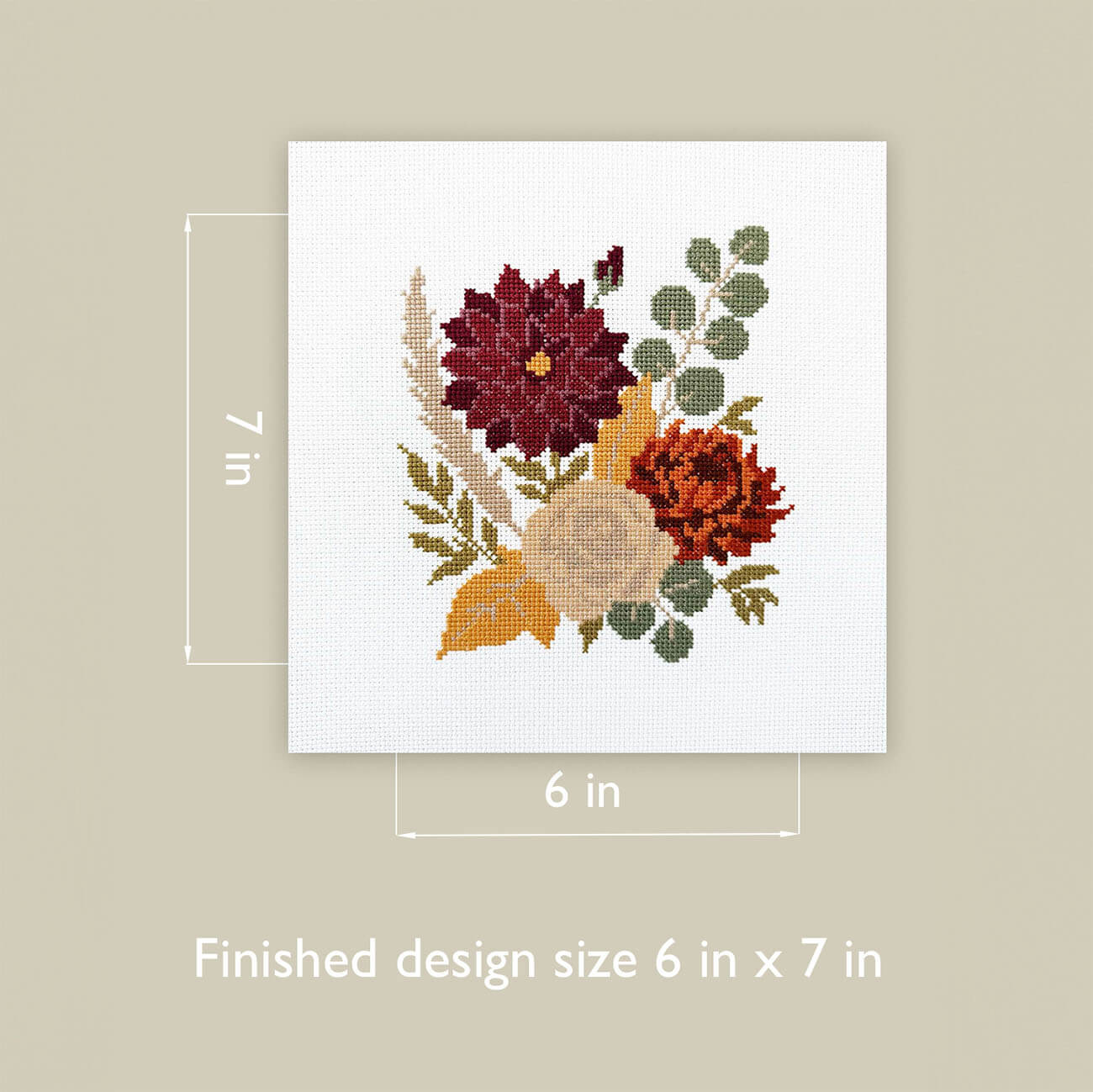 A square white cross-stitch canvas with a floral bouquet design in burgundy, orange, beige, and green, shown on a warm beige background with dimension lines indicating 6 in by 7 in finished size.