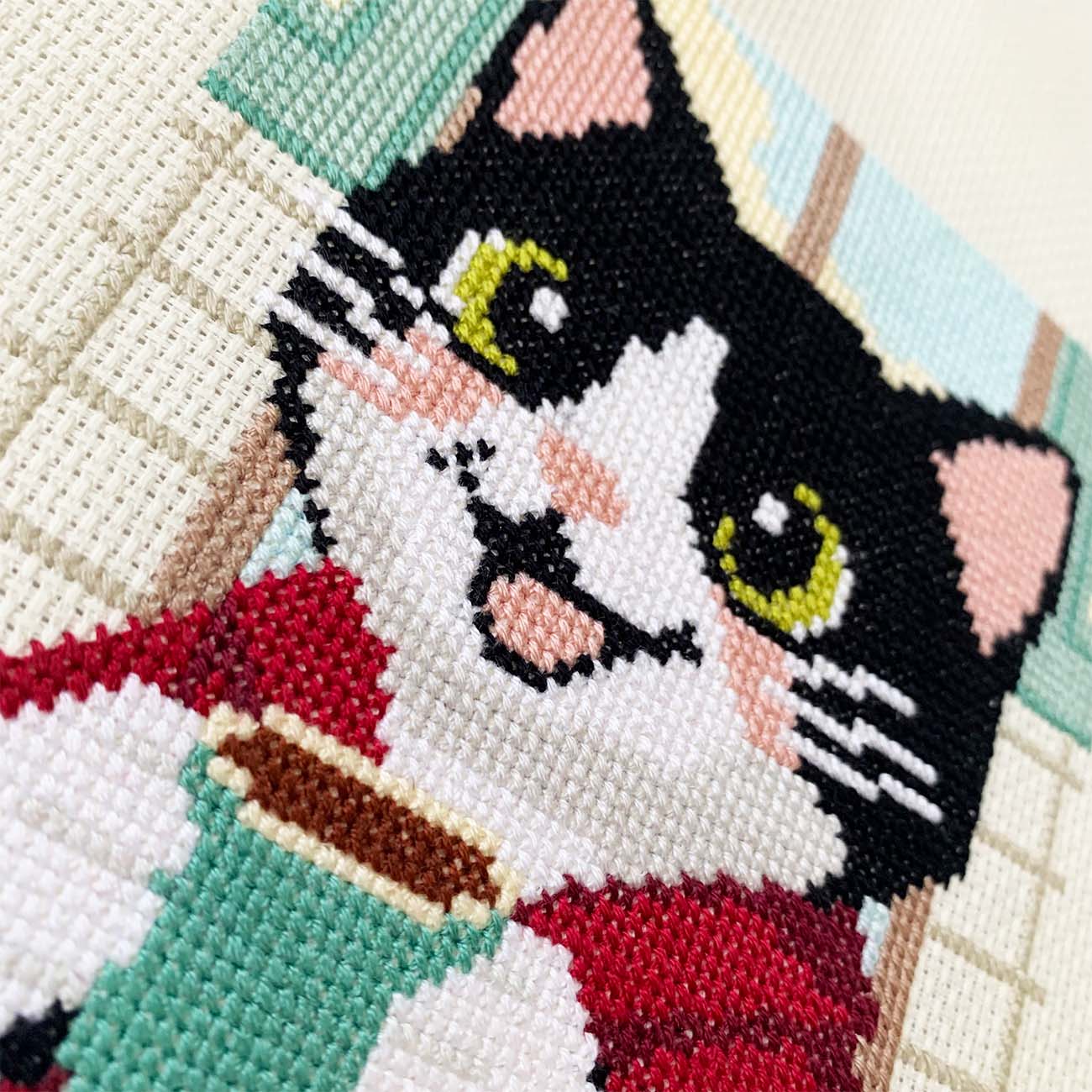 Close-up stitches of Morning Tuxedo Cat cross stitch showing thread texture and color details.