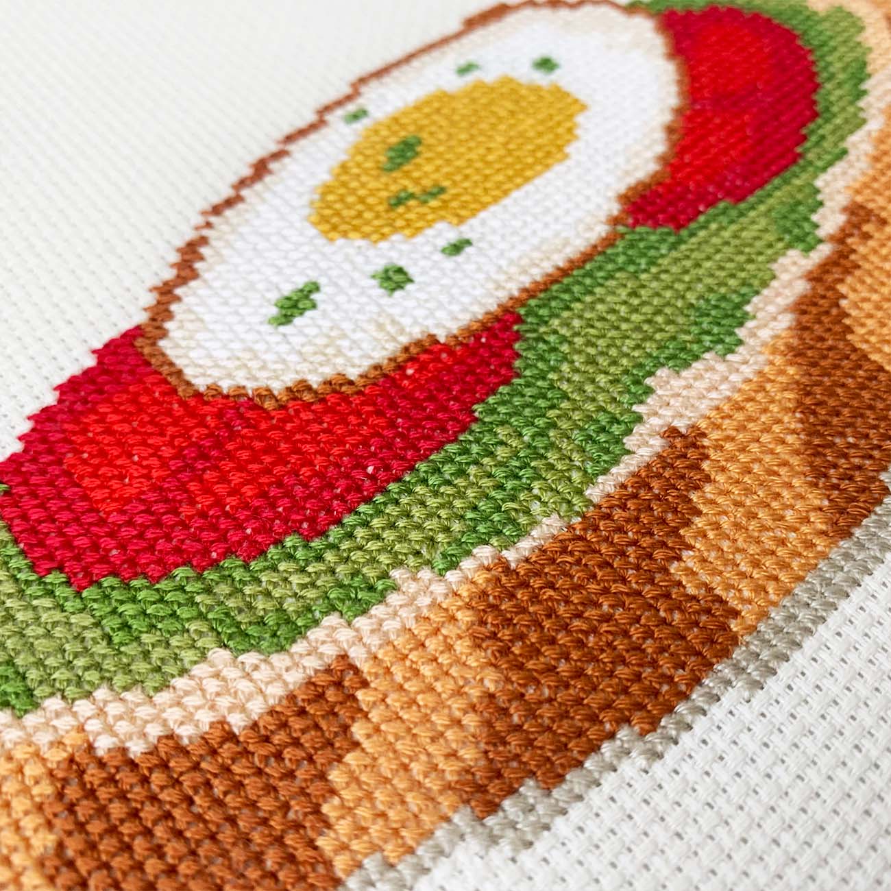 Close-up stitches of Avocado Toast cross stitch showing thread texture and color details.