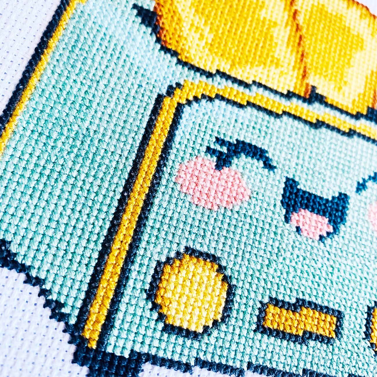 Close-up stitches of Happy Toaster cross stitch showing thread texture and color details.