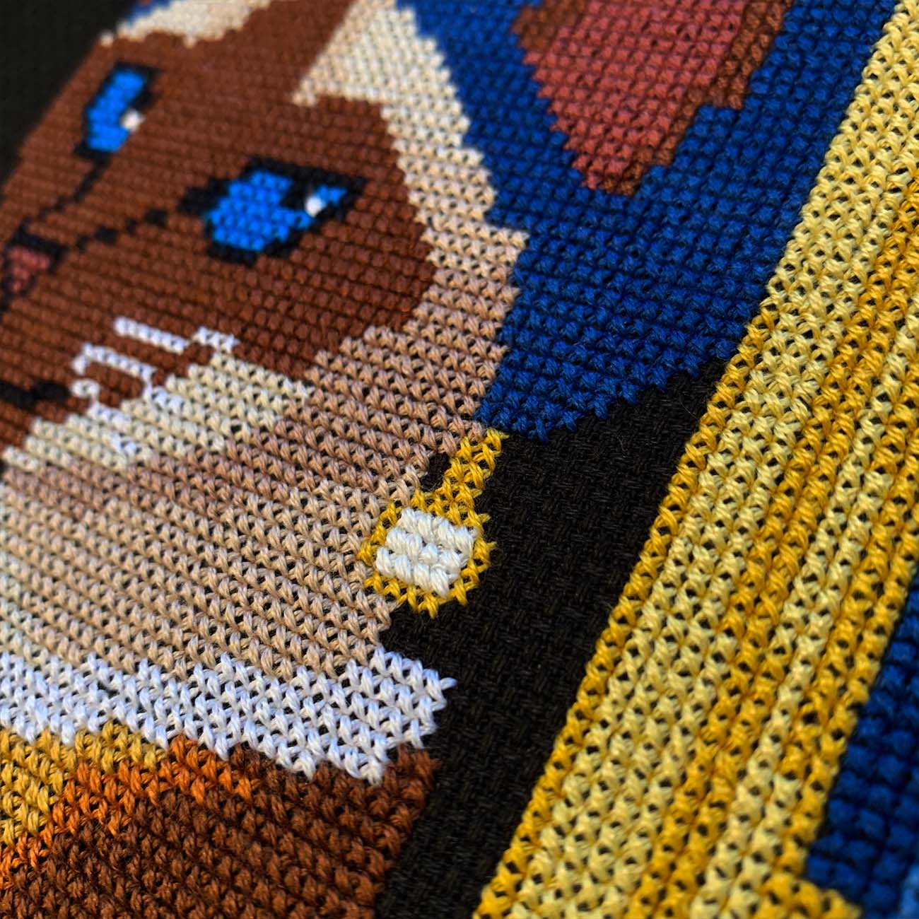 Close-up stitches of Pearl Diva Cat cross stitch showing thread texture and color details.